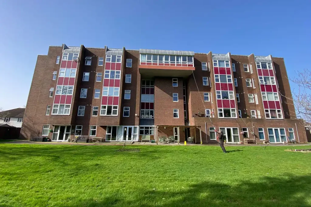 Operative using reach and wash system to clean windows on five-storey residential block at Neptune Court Gosport